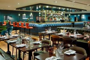 a restaurant with tables and chairs and a bar at Delta Hotels by Marriott Manchester Airport in Hale