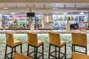 a bar in a hotel with chairs and a counter at Delta Hotels by Marriott Manchester Airport in Hale