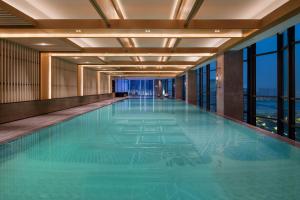 西安的住宿－西安浐灞喜来登酒店，一座大型游泳池,位于一座带窗户的建筑内