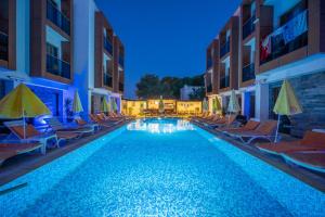 a swimming pool with chairs and umbrellas in a hotel at Majeste Hotel Bodrum in Bodrum City