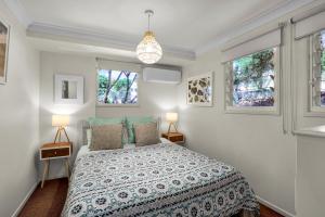 a bedroom with a bed and two windows at Grevillea in Point Lookout
