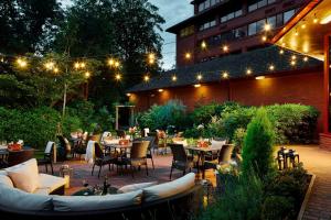 un patio al aire libre con mesas, sillas y luces en Delta Hotels by Marriott Swindon en Swindon