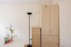 een slaapkamer met een dressoir en een lamp naast een kast bij Fourwinds in Maldon