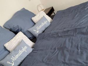 Una cama con sábanas azules y almohadas. en Ferienwohnung Heistenbach bei Diez/Limburg, en Heistenbach