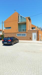 a car parked in a parking lot in front of a building at Casa Jardins da Praia in Póvoa de Varzim