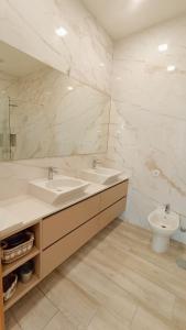 a white bathroom with a sink and a toilet at Casa Jardins da Praia in Póvoa de Varzim
