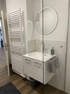 a white bathroom with a sink and a mirror at Ferienwohnung Heistenbach bei Diez/Limburg in Heistenbach