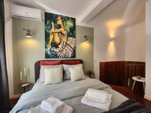a bedroom with a bed with a painting on the wall at Lovely Studio in center of Bucharest in Bucharest