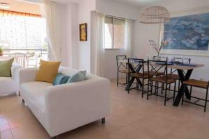 sala de estar con sofá blanco y mesa en Gran apartamento, Aire acondicionado, piscina y parking gratuito, en Alicante