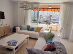 ein Wohnzimmer mit 2 Sofas und einem Tisch in der Unterkunft Gran apartamento, Aire acondicionado, piscina y parking gratuito in Alicante