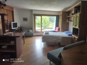 Schlafzimmer mit einem Bett, einem Schreibtisch und einem Fenster in der Unterkunft Appartamento Pila in Pila