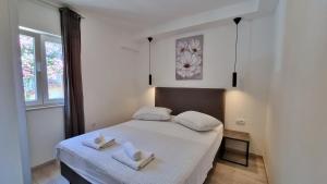 ein Schlafzimmer mit einem Bett mit zwei Handtüchern darauf in der Unterkunft Apartments Zorica in Duće