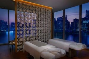 a bedroom with two beds and a window with a city skyline at The St. Regis Downtown Dubai in Dubai