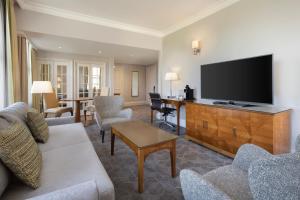 a living room with a couch and a flat screen tv at Delta Hotels by Marriott Birmingham in Birmingham