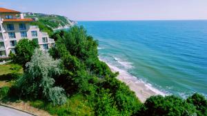 a building on a hill next to a beach at Плажни Апартаменти Силвър Бийч - Silver Beach Sea Apartments in Byala