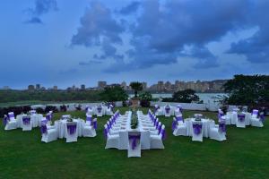 a group of white tables and chairs on a field at The Westin Mumbai Powai Lake in Mumbai