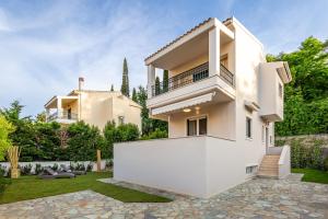una casa bianca con un giardino di fronte di Magdalena Home Corfu a Città di Corfù