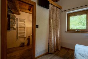 una camera da letto con una porta che conduce a una finestra di Le Vieux Noyer - Appartamenti al Verde villaggio di Rumiod a Saint-Pierre