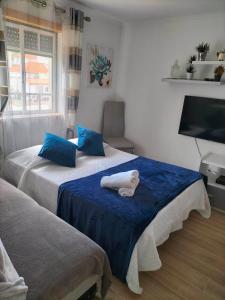 a bedroom with two beds with blue pillows at Moradia Meca - Casas para Férias in Nazaré