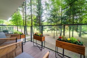 a balcony with two planters with flowers on it at Lake Park Apartament in Mikołajki