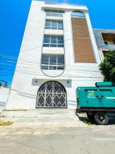 a green dump truck parked in front of a building at White Town By Ashoka Group in Udaipur