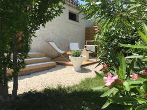 a backyard with a patio with a chair and a toilet at La Maison 1440 in L'Isle-sur-la-Sorgue