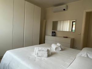 ein Schlafzimmer mit einem weißen Bett und Handtüchern darauf in der Unterkunft Sotto le Mura, appartamento Ponti in Siena
