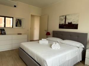 ein Schlafzimmer mit einem großen Bett mit weißer Bettwäsche in der Unterkunft Sotto le Mura, appartamento Ponti in Siena