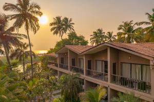 ein Haus am Strand mit Palmen in der Unterkunft Riva Beach Resort in Mandrem