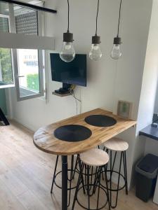 een houten tafel in een kamer met 2 krukken bij Superbe studio au cœur de Nice ! in Nice