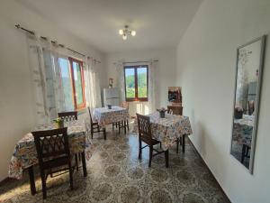 a dining room with two tables and chairs and windows at La valle fiorita in Soviore