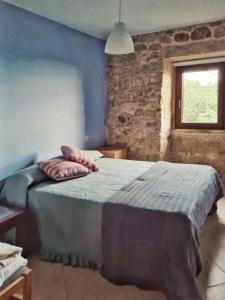ein Schlafzimmer mit einem Bett in einem Zimmer mit einem Fenster in der Unterkunft Alojamiento Casa Carlota in Villadesuso