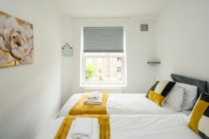 a bedroom with two beds and a window at Cosy 3BD London accommodation for 6 / 6 beds in London