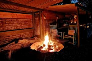 a fire pit in a room with two chairs at Penn Bergeyn Shepherd's Huts in Exeter