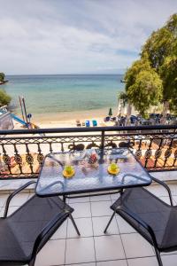 a table on a balcony with a view of the beach at Casa di Zou in Skala Marion