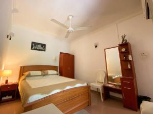 1 dormitorio con cama, tocador y espejo en Agasthi Airport Close en Katunayaka