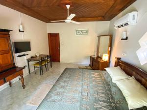 a bedroom with a bed and a desk and a television at Agasthi Airport Close in Katunayaka