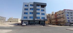 ein Gebäude mit einem davor geparkt in der Unterkunft فندق حياة تاون 2 in Umm Lajj