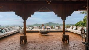 a woman sitting on a table in a pavilion with couches at Malabar Hill in Weligama
