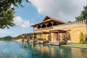 a building next to a body of water at Malabar Hill in Weligama