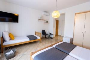 a room with two beds and a tv on the wall at LUXURY ROOMS BURE in Murter