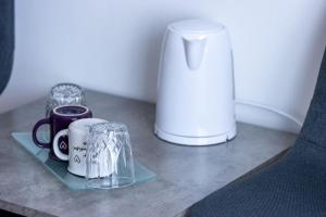 a table with cups and a vase on it at LUXURY ROOMS BURE in Murter