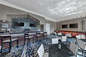 a restaurant with tables and chairs and a bar at Renaissance Dallas North Hotel in Dallas