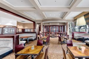 un restaurante con mesas y sillas y un bar en Renaissance Dallas North Hotel, en Dallas
