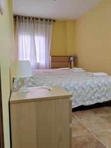 - une chambre avec un lit et une table avec une lampe dans l'établissement Apartamento MG, à Huelva