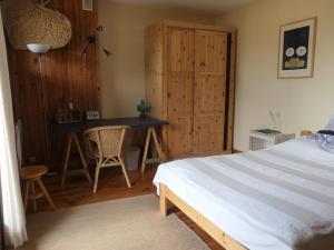 een slaapkamer met een bed, een tafel en een bureau bij Le Ginkgo - Mont Dauphin in Eygliers