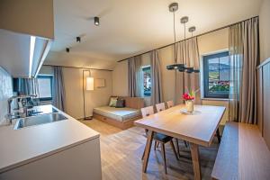 a kitchen and dining room with a table and a kitchen and a living room at Apartments Am Platzl Living in Laion