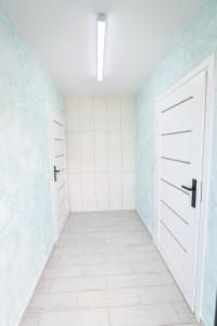 Habitación vacía con 2 puertas blancas y paredes azules en KempingZator, en Zator