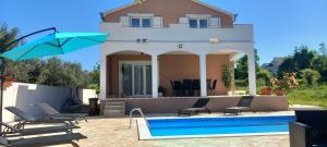 a villa with a swimming pool and a house at Leggiero in Benkovac