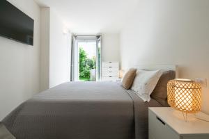 a white bedroom with a bed and a window at La casa di Guido in Gabicce Mare